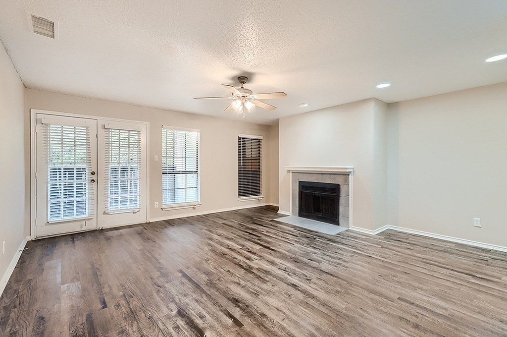 A spacious living room with a fireplace and sliding glass doors.