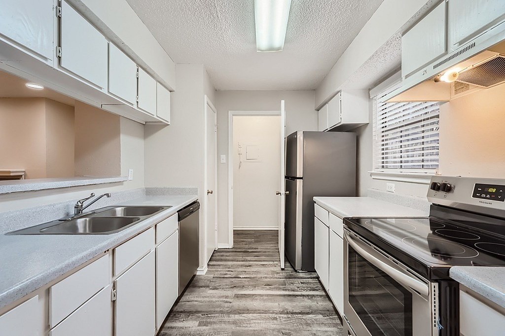 A kitchen with white cabinets and stainless steel appliances.