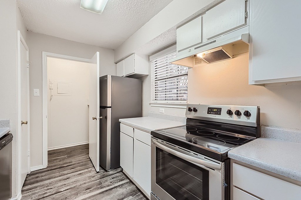 A kitchen with a stove, oven, and refrigerator.