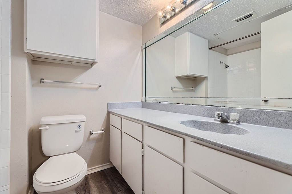 A white toilet is next to a sink in a small bathroom.
