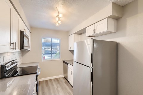 A kitchen with a stainless steel refrigerator and oven.