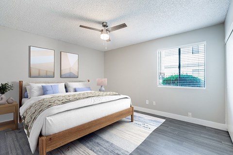 A bedroom with a large bed and a ceiling fan.