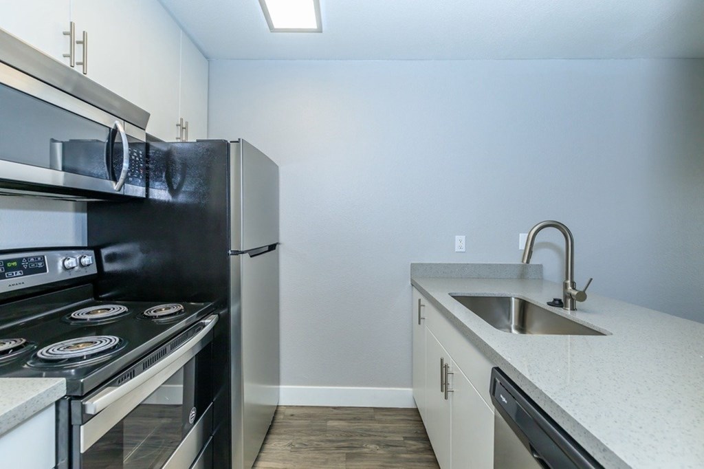 A kitchen with a black stove top oven and a white counter top.