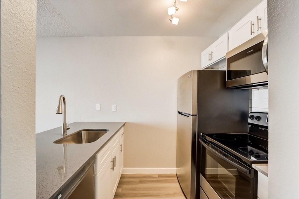 A kitchen with a stainless steel sink and oven.