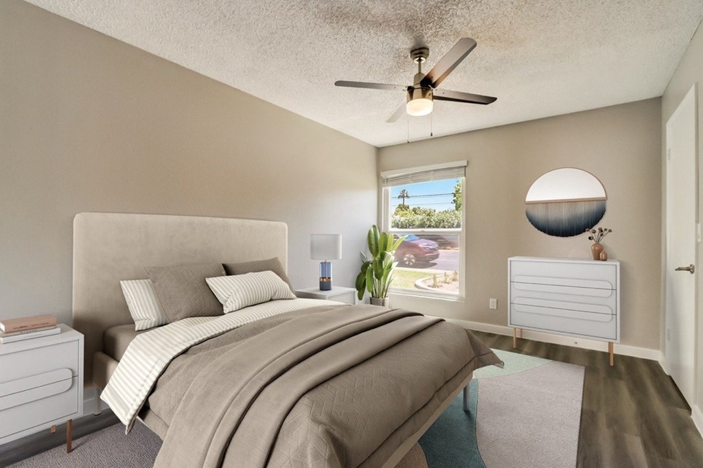 A bedroom with a large bed and a ceiling fan.