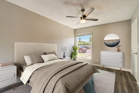 A bedroom with a large bed and a ceiling fan.