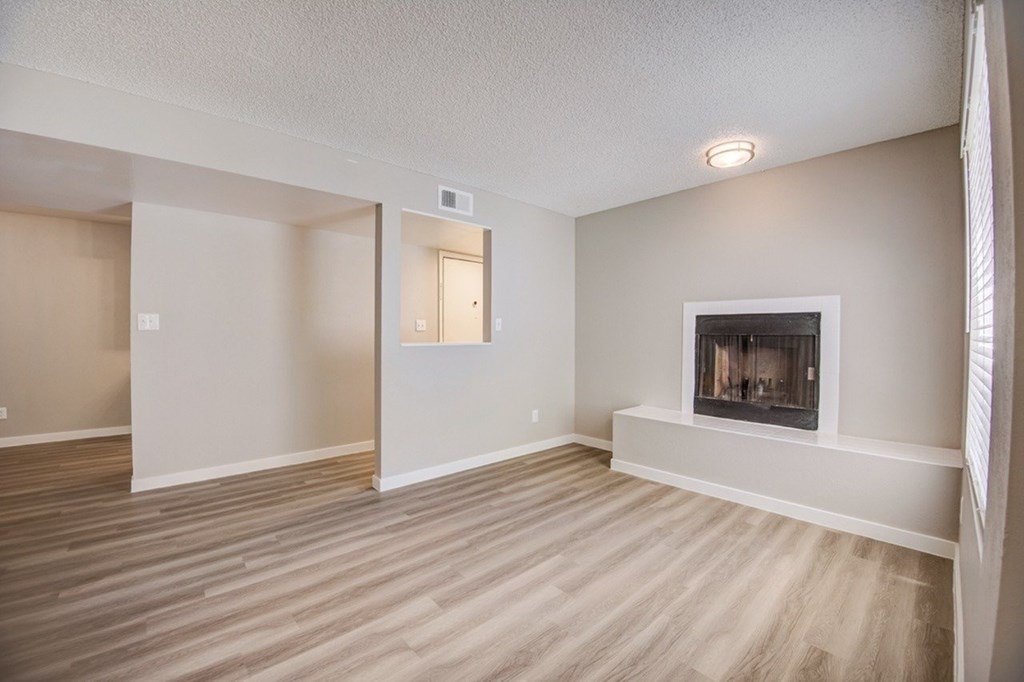 A room with a fireplace and wood flooring.