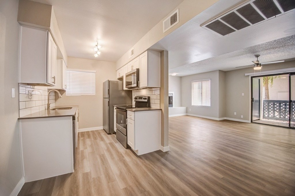 A kitchen with white cabinets and a stainless steel refrigerator.