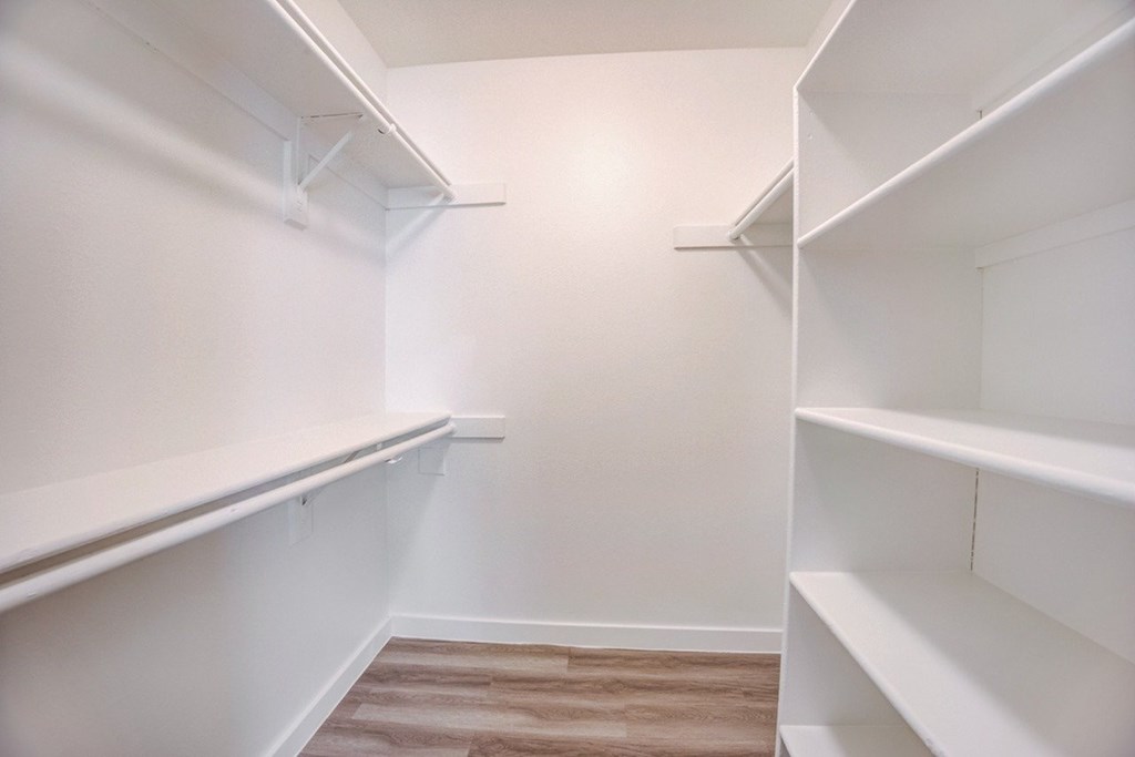 Empty white shelves in a room with wooden flooring.
