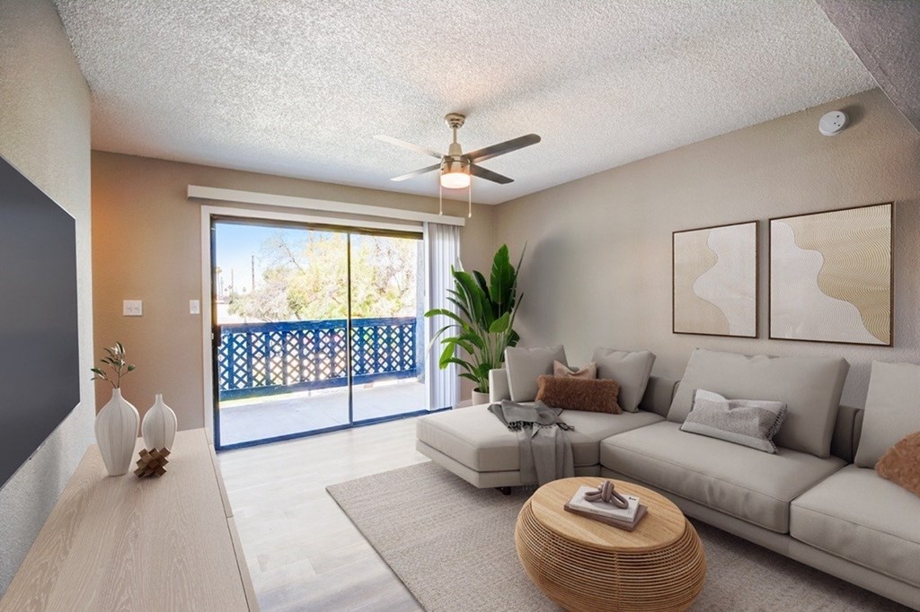 A living room with a grey couch, a coffee table, and a ceiling fan.