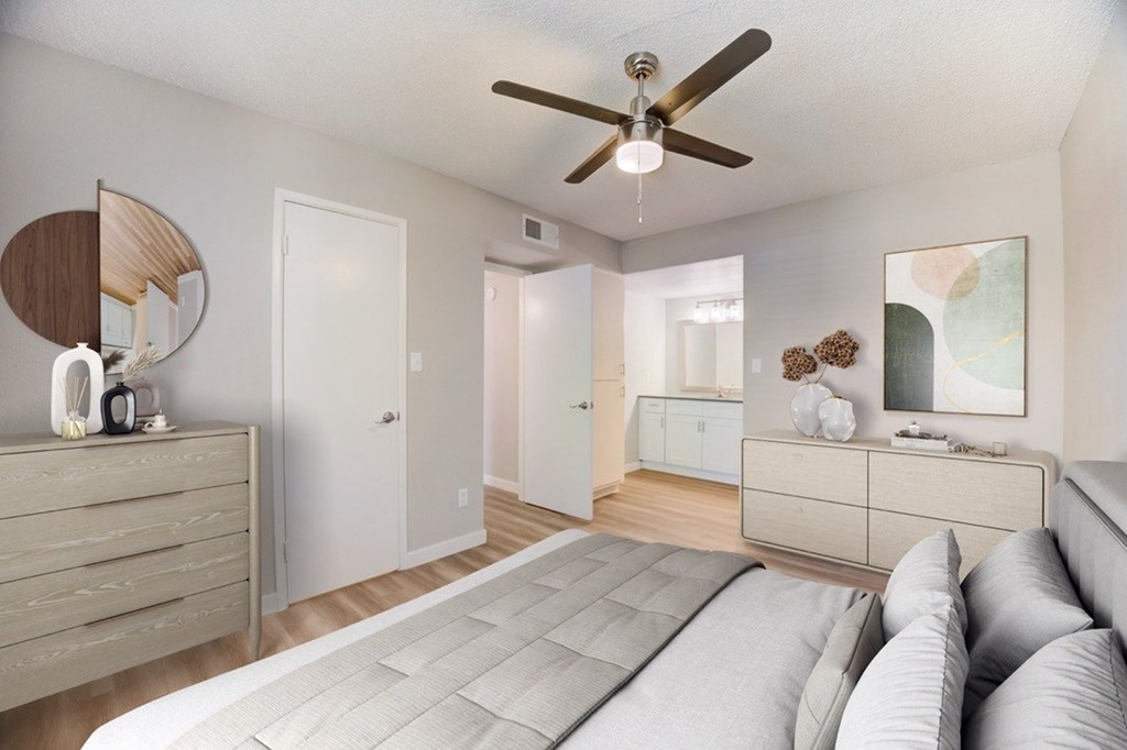 A bedroom with a bed, dresser, and mirror.