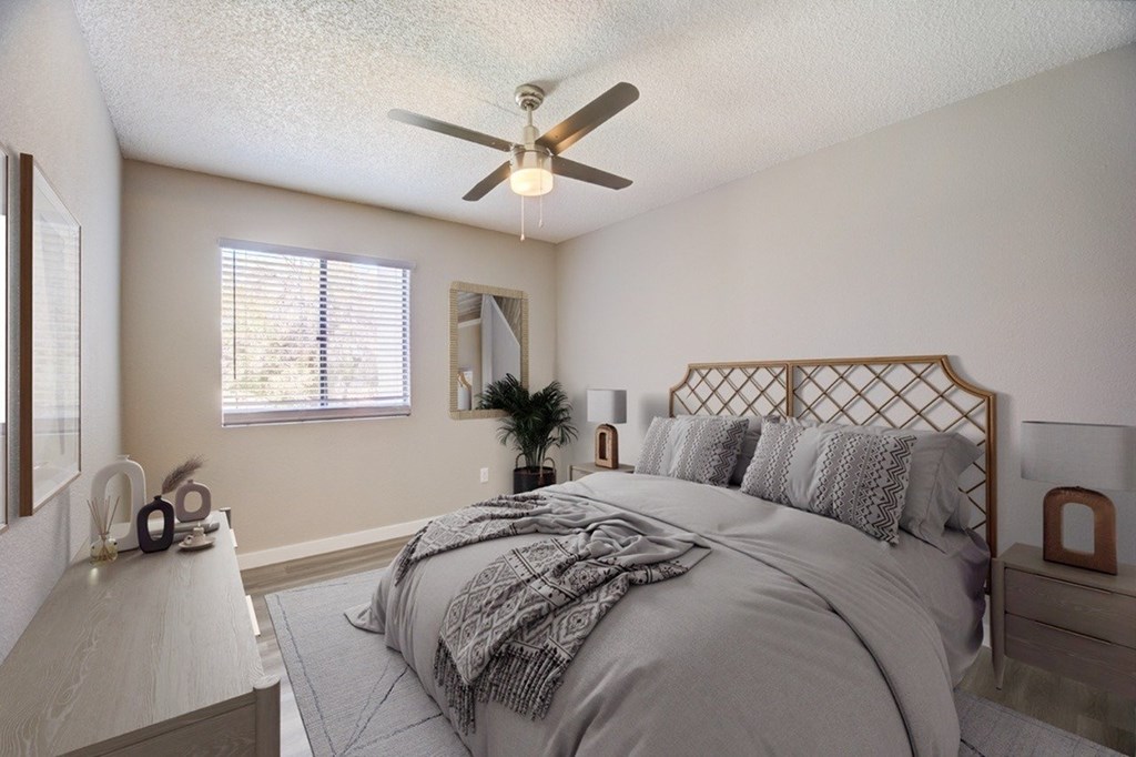 A bedroom with a large bed and a ceiling fan.