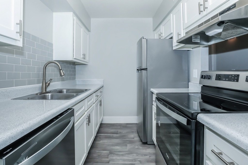 A modern kitchen with stainless steel appliances and white cabinets.