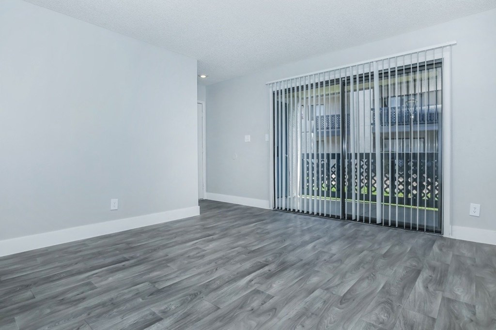 A room with a sliding door and wooden flooring.