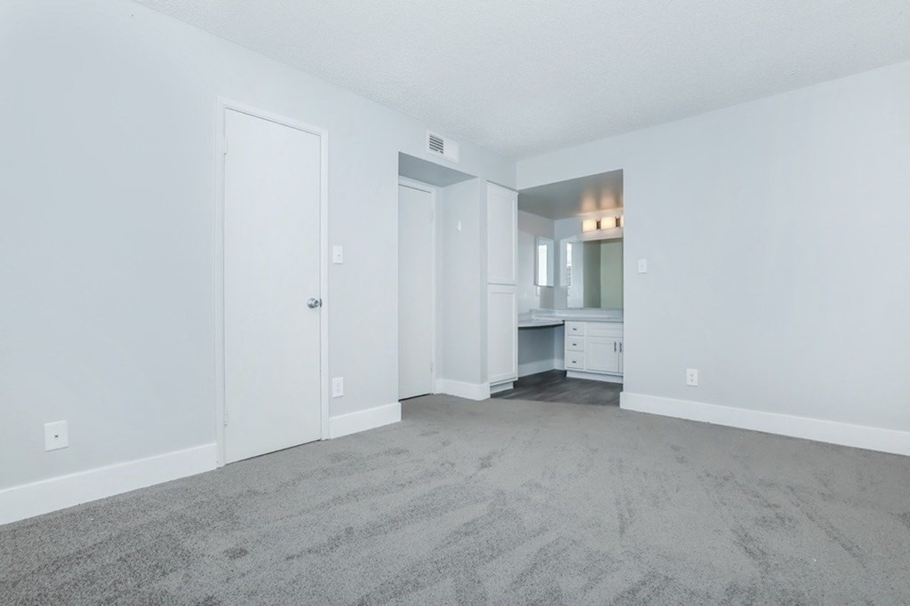 A room with a carpeted floor and a white door.