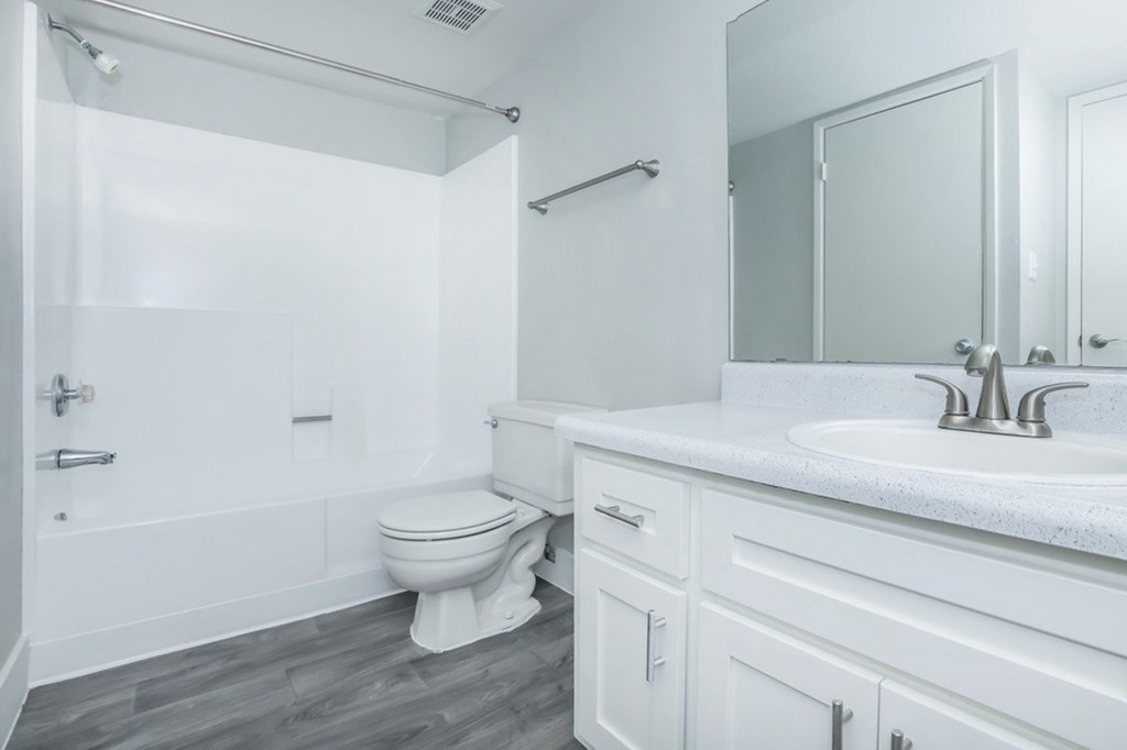 A white bathroom with a toilet, sink, and bathtub.