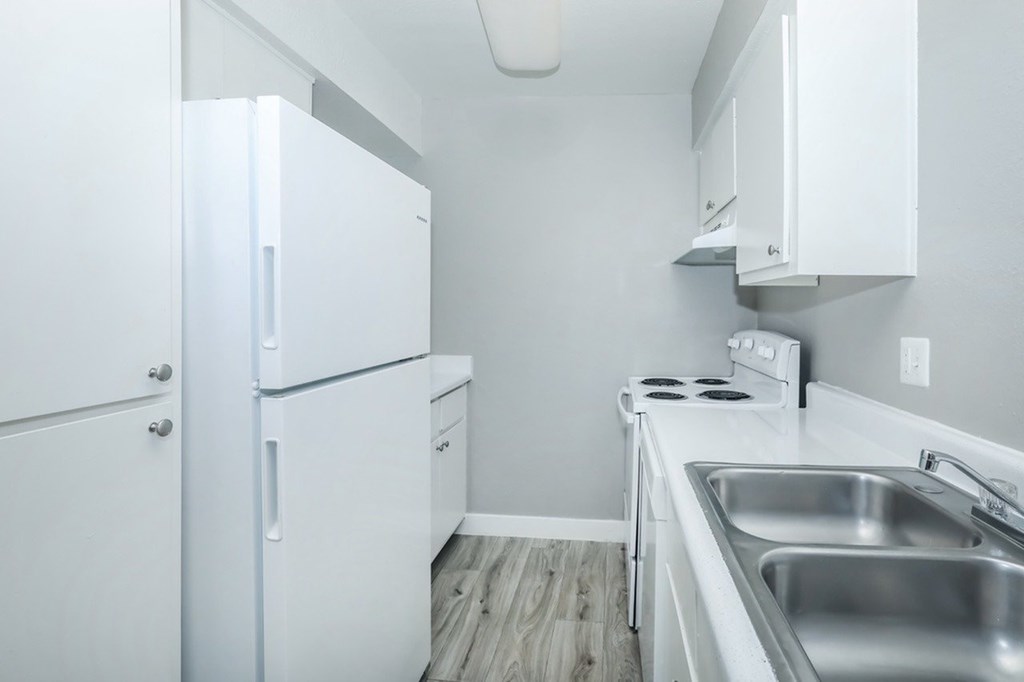 A kitchen with white appliances and cabinets.