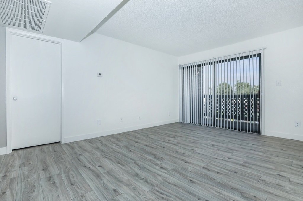 A room with a white door and a window with bars.
