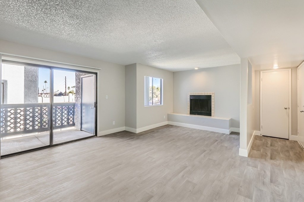 A spacious living room with a fireplace and sliding glass doors.