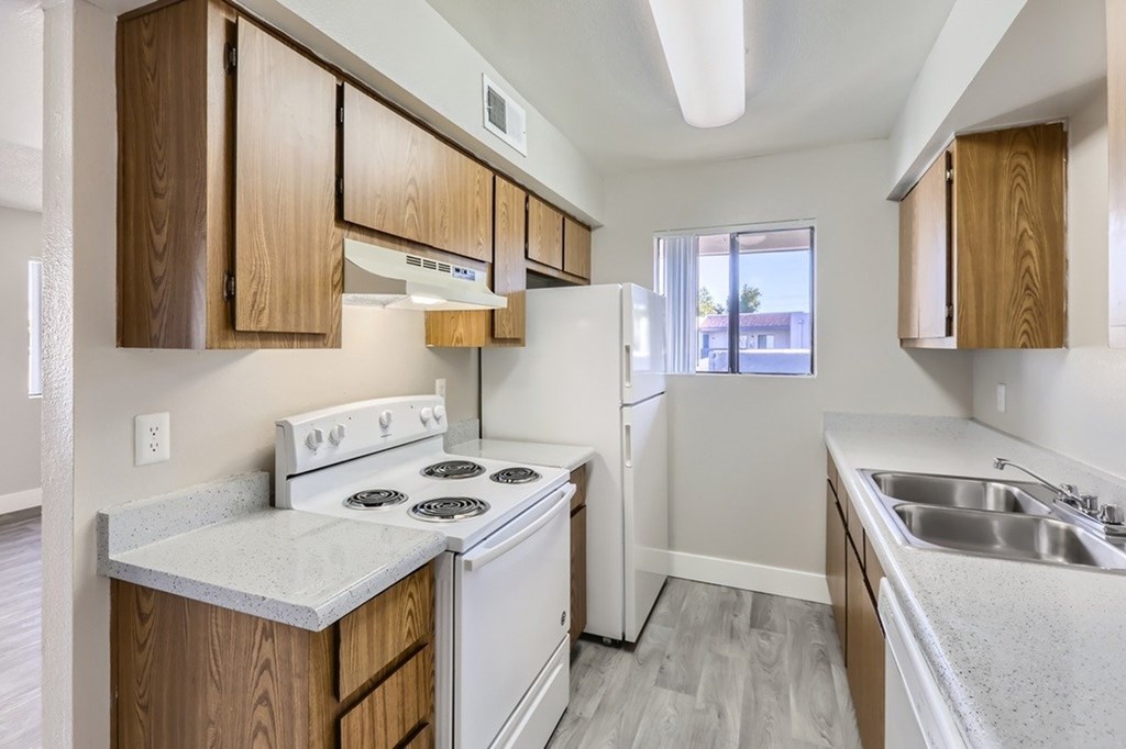 A kitchen with white appliances and wooden cabinets.
