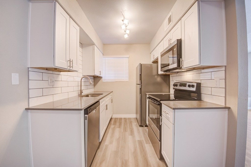 A kitchen with white cabinets and stainless steel appliances.