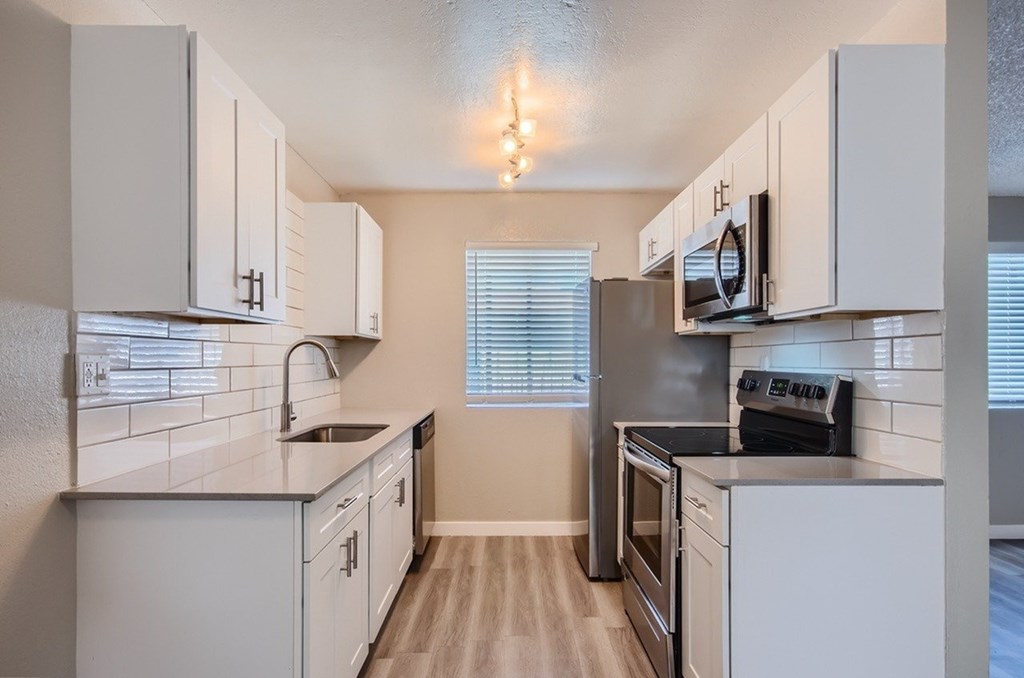 A kitchen with white cabinets and a black stove top oven.