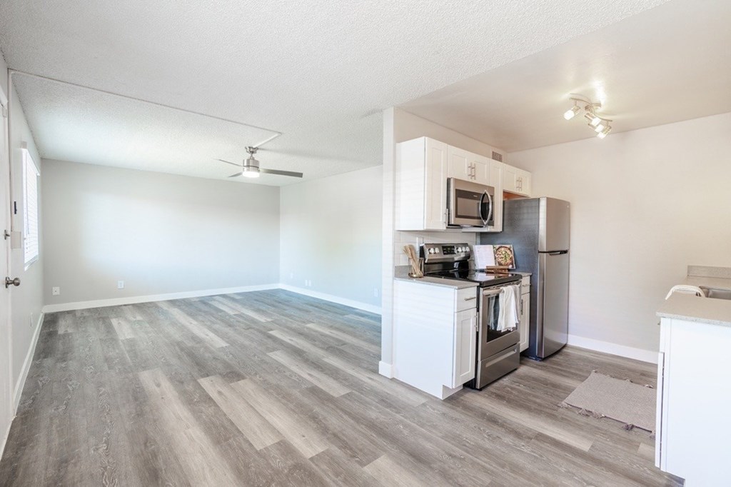 A kitchen with a refrigerator, microwave, and oven.