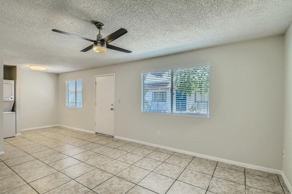 A room with a ceiling fan and tiled flooring.