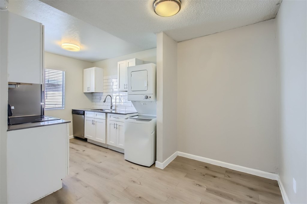 A kitchen with white cabinets and appliances.