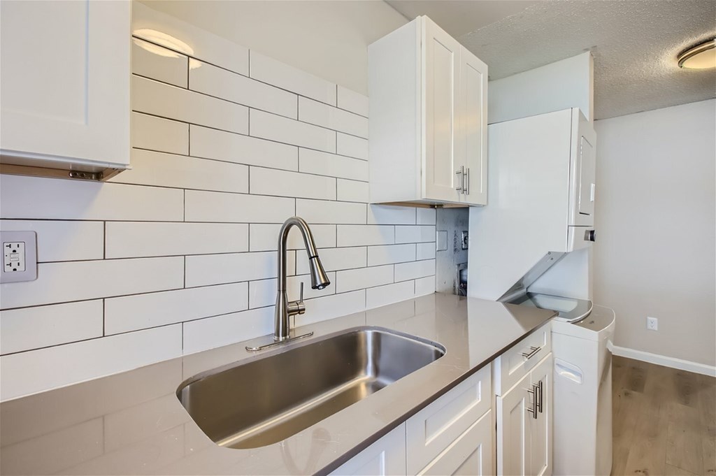 A kitchen with a sink and a refrigerator.