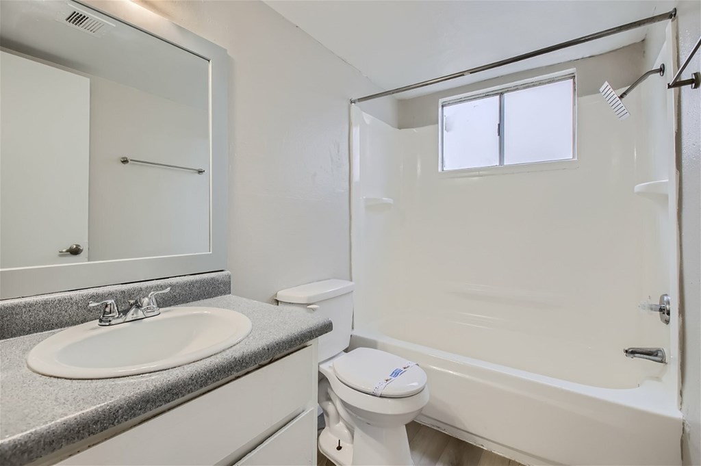 A white bathroom with a sink, toilet, and bathtub.