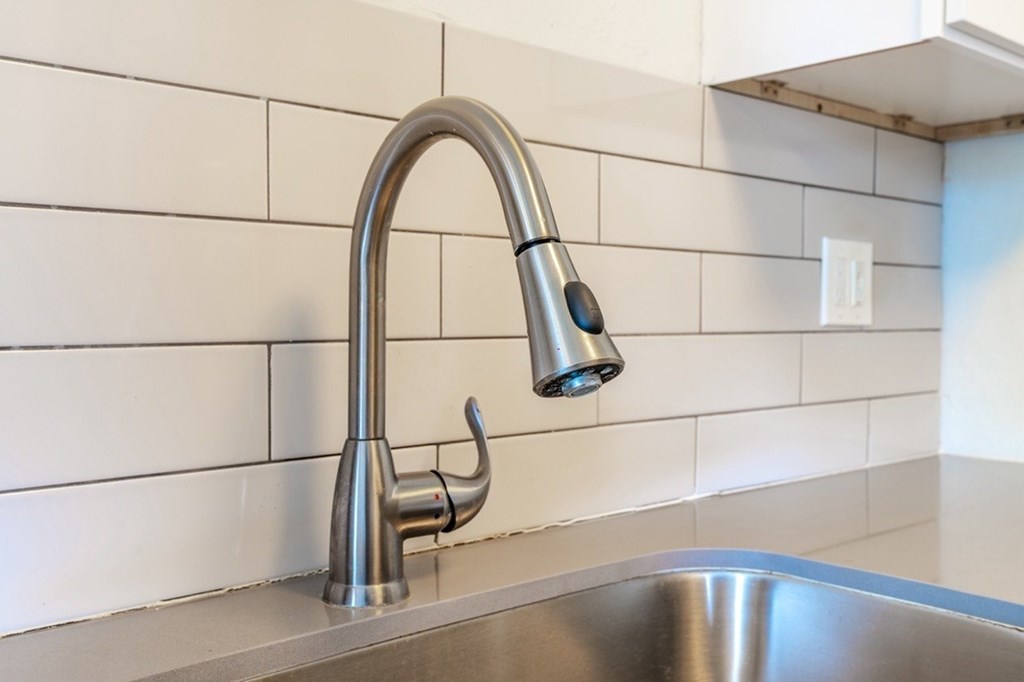 A modern kitchen sink with a chrome faucet.