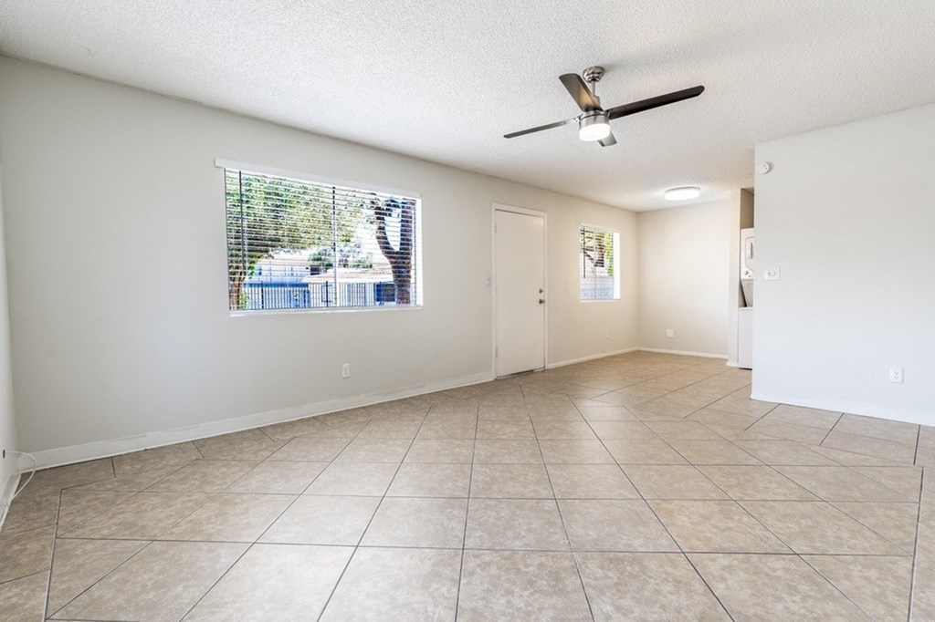 A room with a ceiling fan and a window showing an outdoor scene.