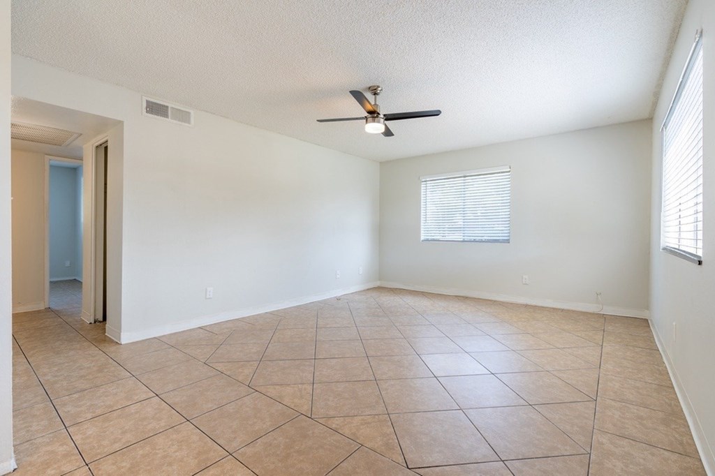 Empty room with tiled floor and ceiling fan.