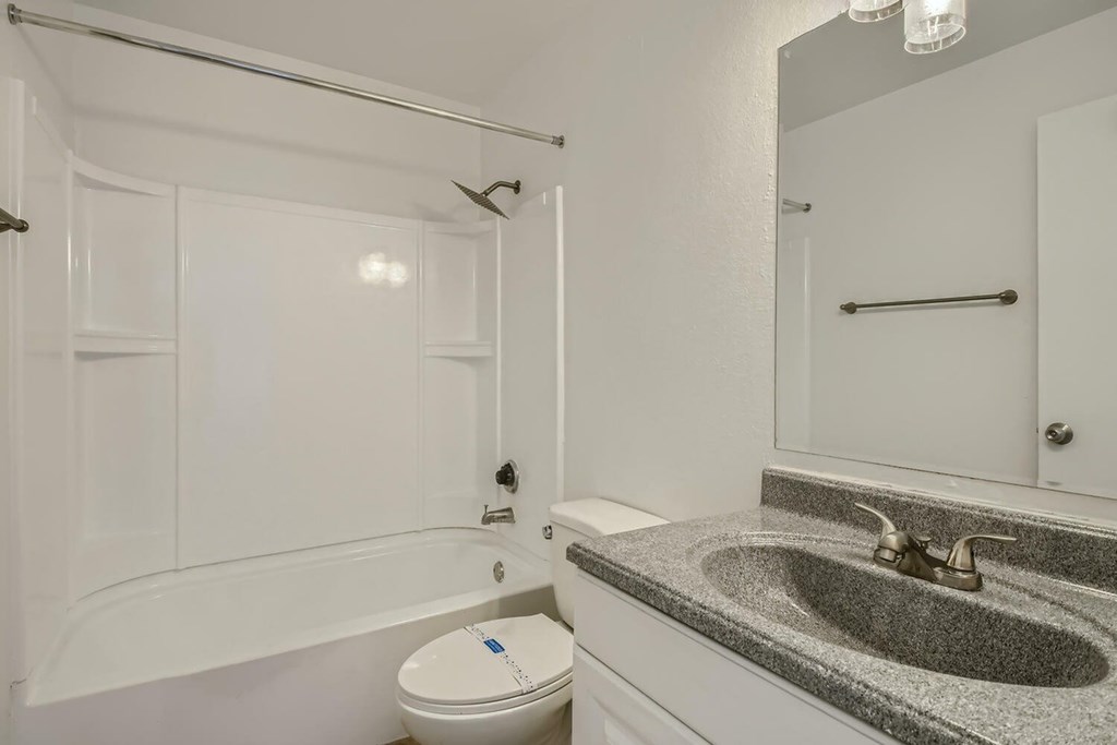 A white bathroom with a toilet, sink, and bathtub.