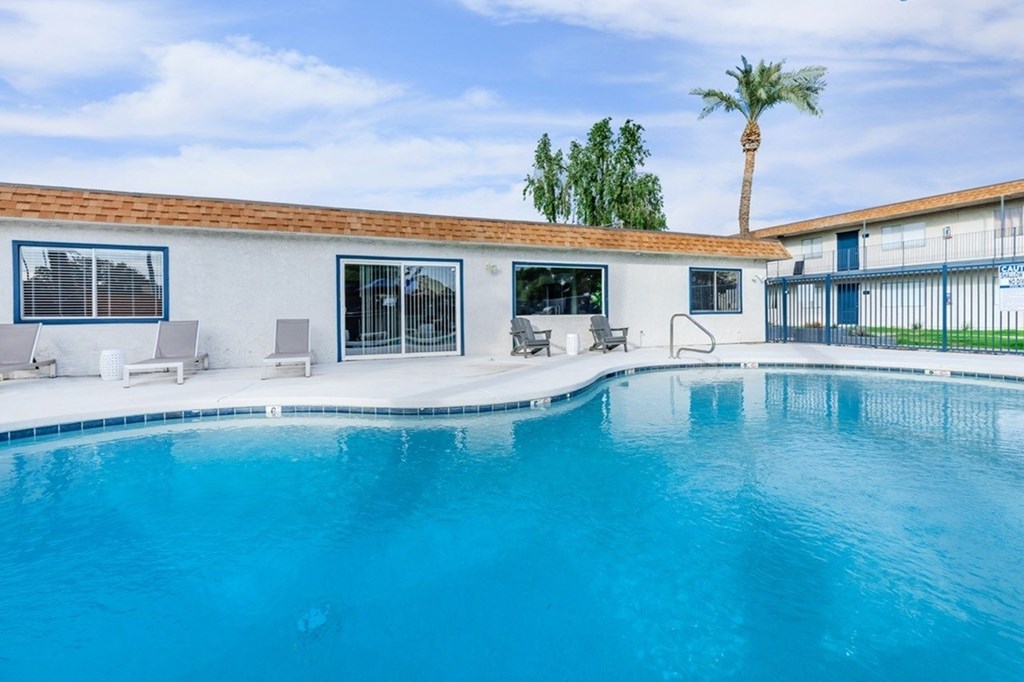 A pool in a house with a palm tree in the background.