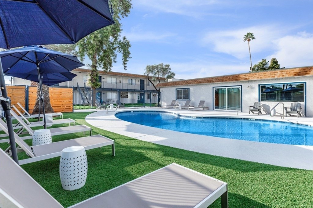 A pool with a white bench and a white vase in the foreground.
