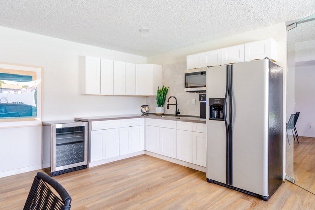 A kitchen with a refrigerator, microwave, and oven.
