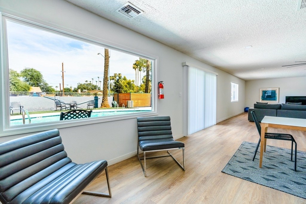 A living room with a black leather couch and a grey chair.