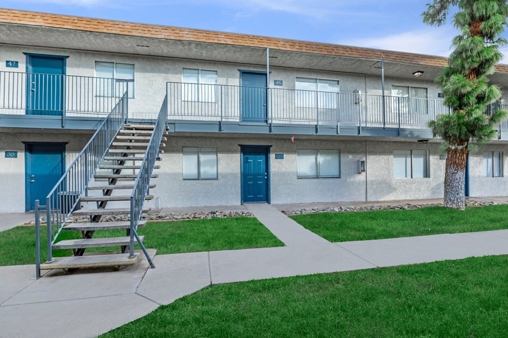 A building with blue doors and a tree in front.