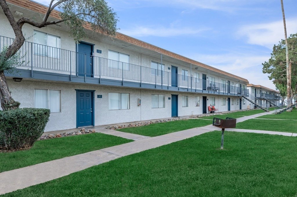 A row of white apartment buildings with blue doors and windows.