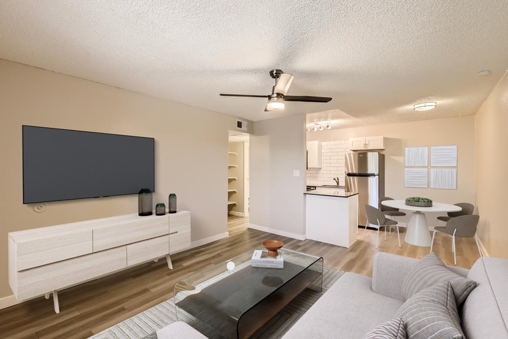A modern living room with a grey sofa and a black television.