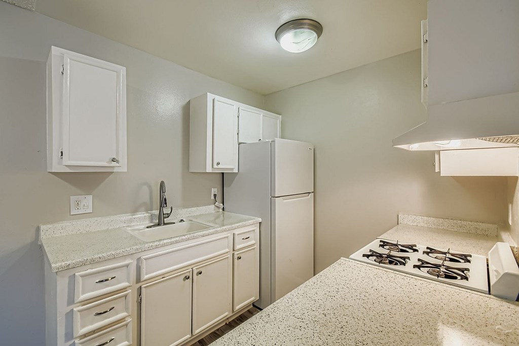 A bedroom with a bed, couch, and a ceiling fan.