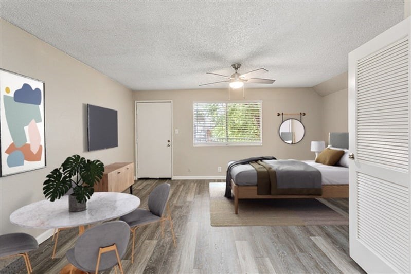 A bedroom with a bed, a table, and chairs.