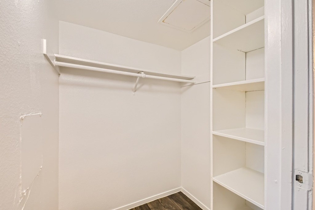 A white closet with shelves and a door.