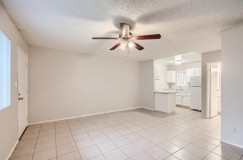A room with a ceiling fan and tiled flooring.
