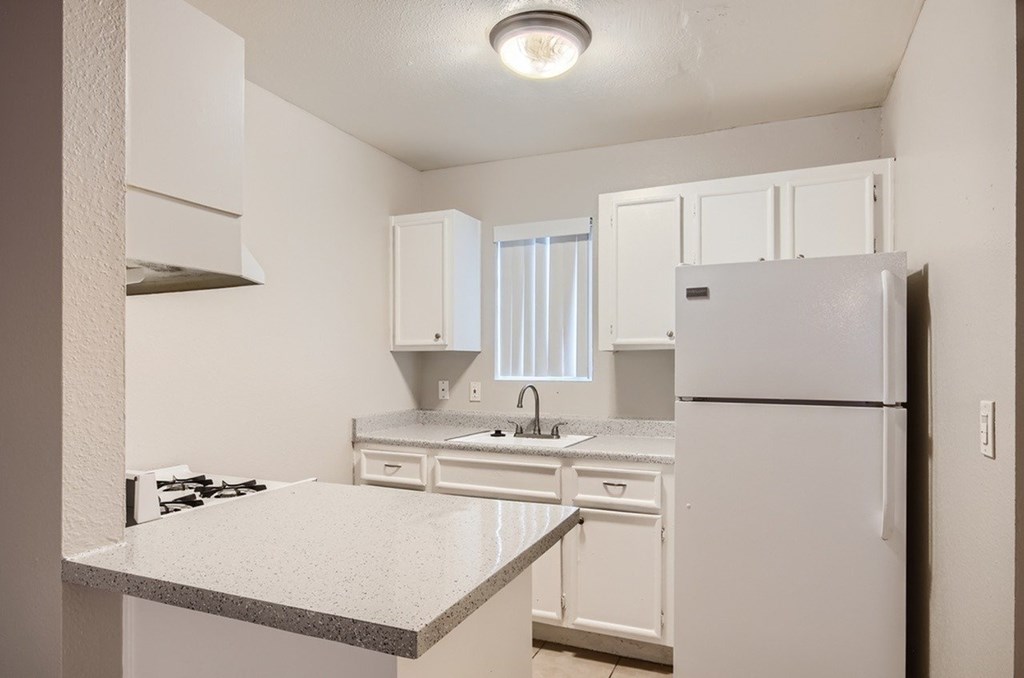 A kitchen with white appliances and cabinets.