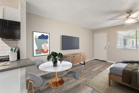 A modern living room with a grey sofa and a round table with chairs.