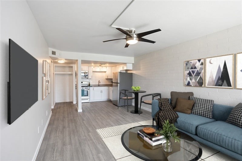 A living room with a couch, a coffee table, and a ceiling fan.