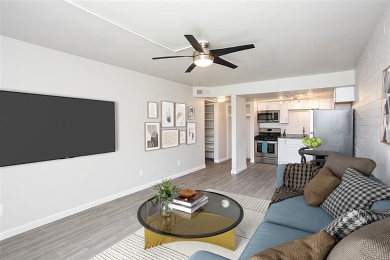 A living room with a couch, coffee table, and a ceiling fan.